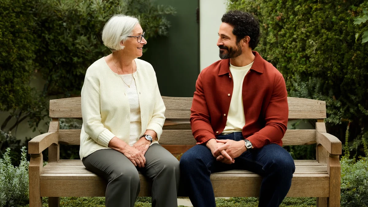 two adults of different generations seated together on a garden bench