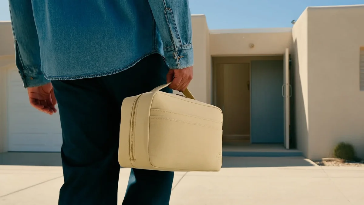 adult arriving at a welcoming building with a small overnight bag