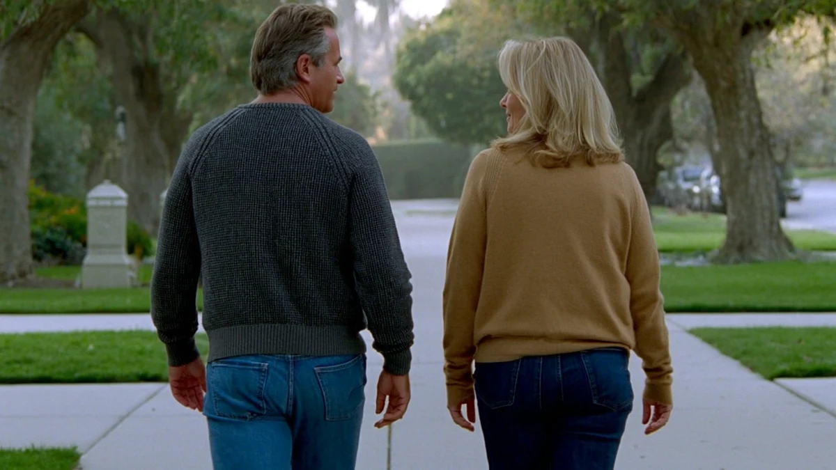 two adults walking together on a quiet tree-lined path